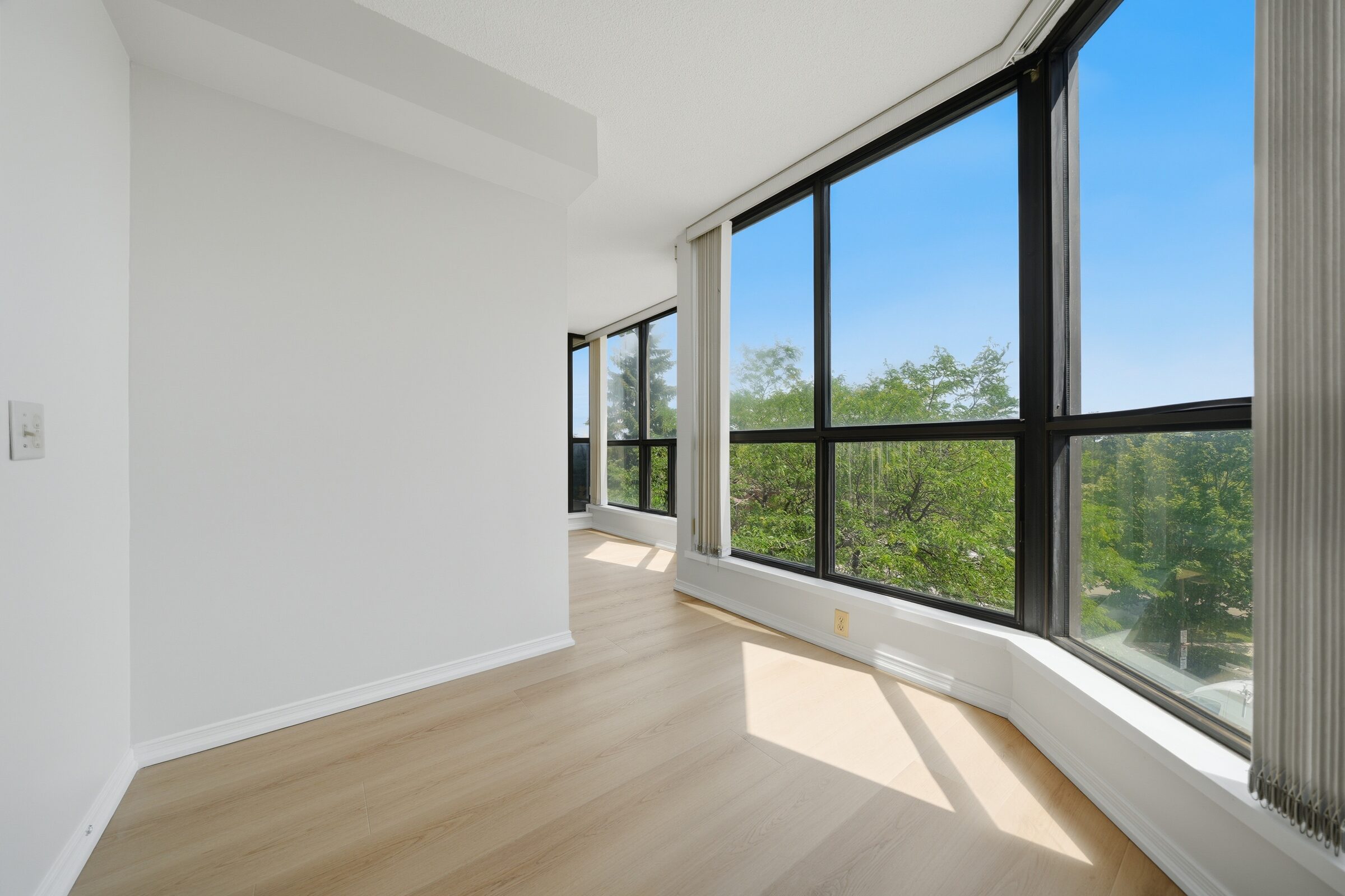 Sun-filled den with wraparound windows and city views