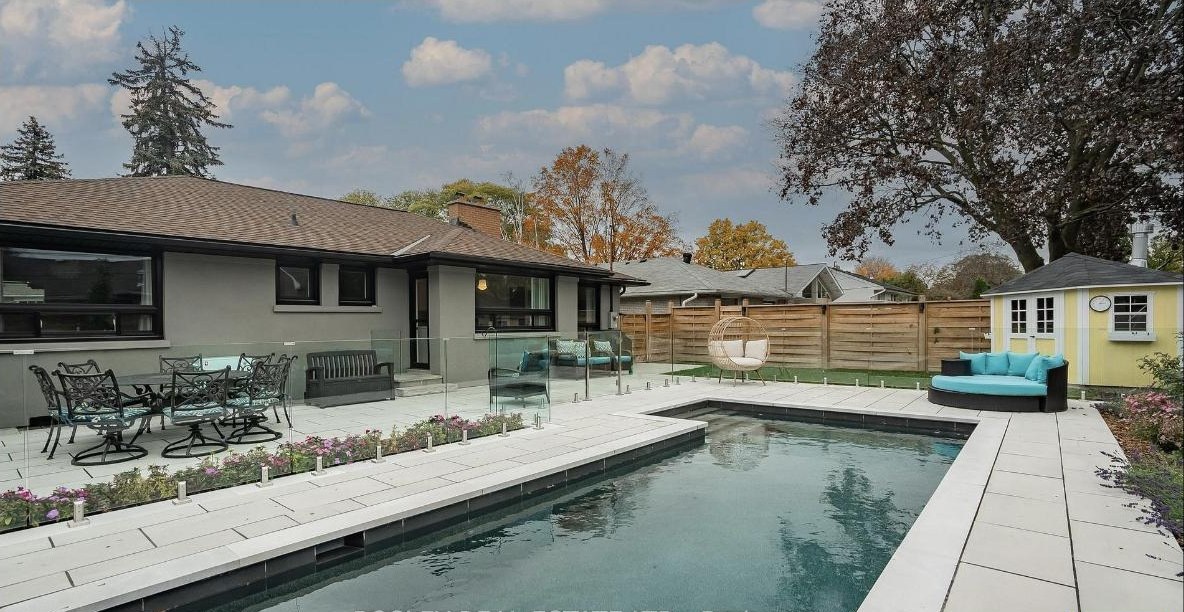 Heated inground pool and stone patio behind the house