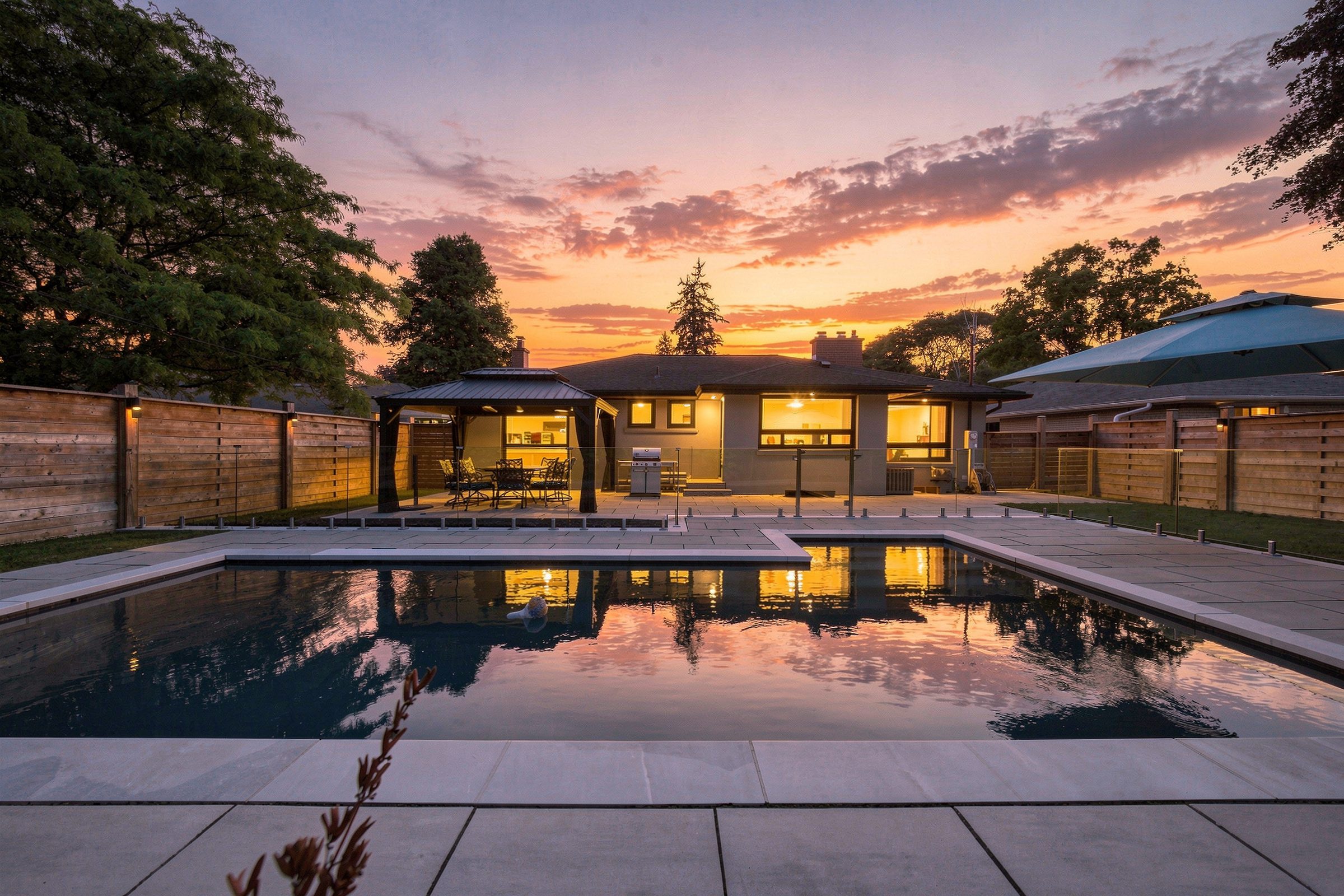 The heated inground pool and stone terrace at 16 Oldham Road at twilight