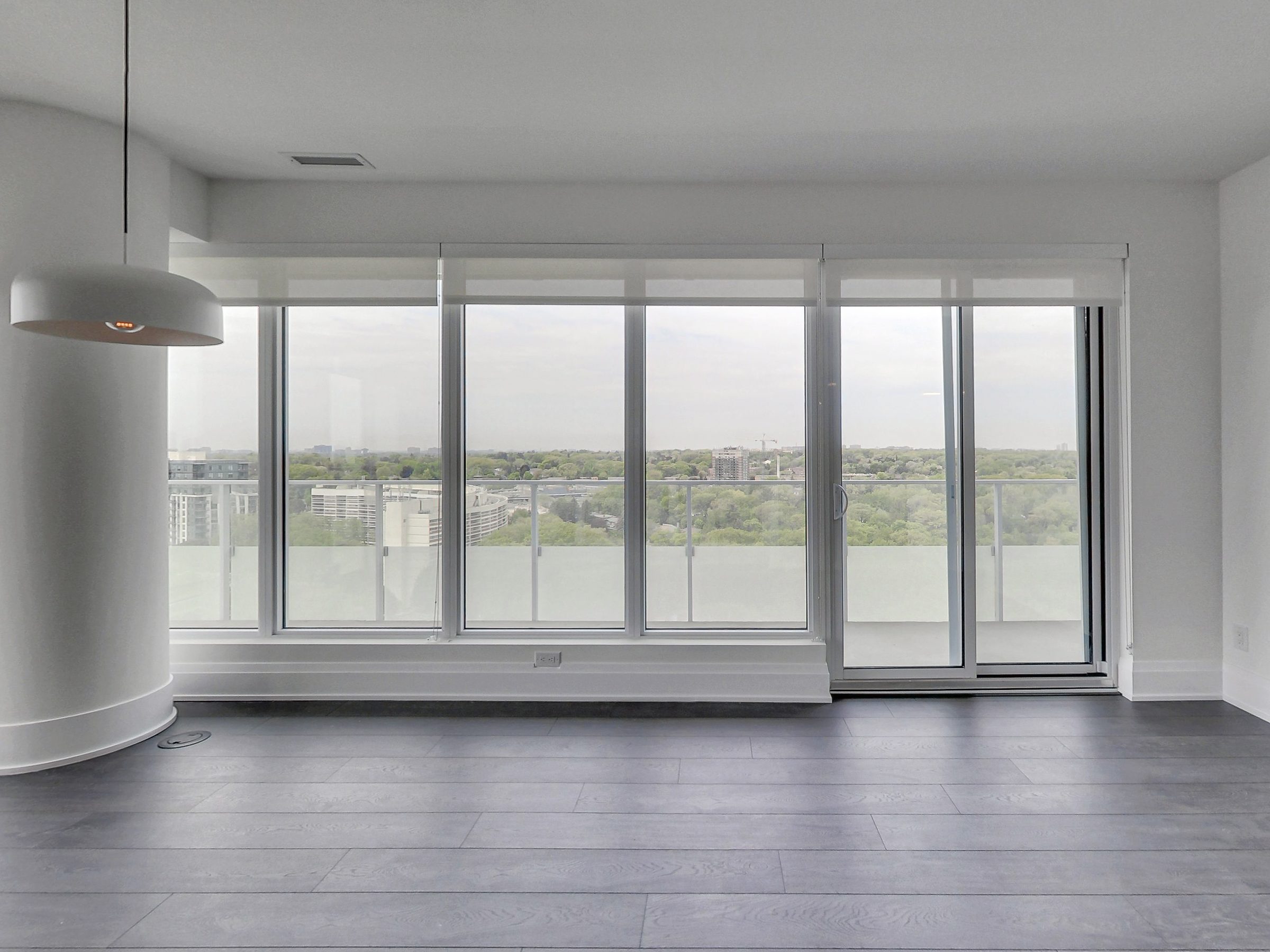 Living and dining framed by a wall of glass over the Humber