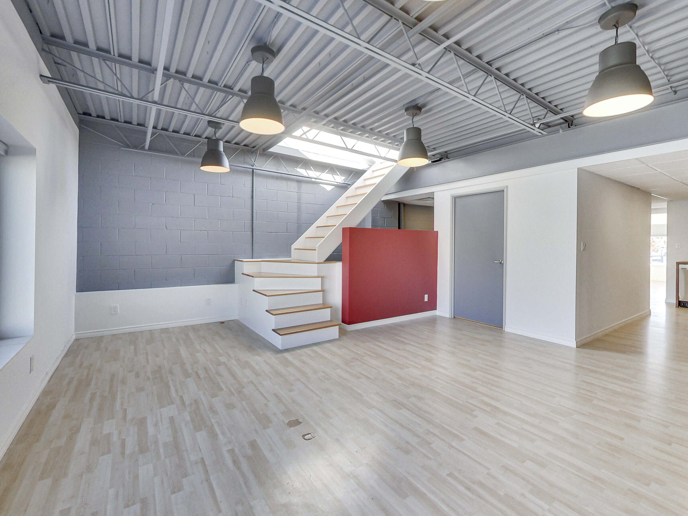 Open-concept principal living space with skylight stair