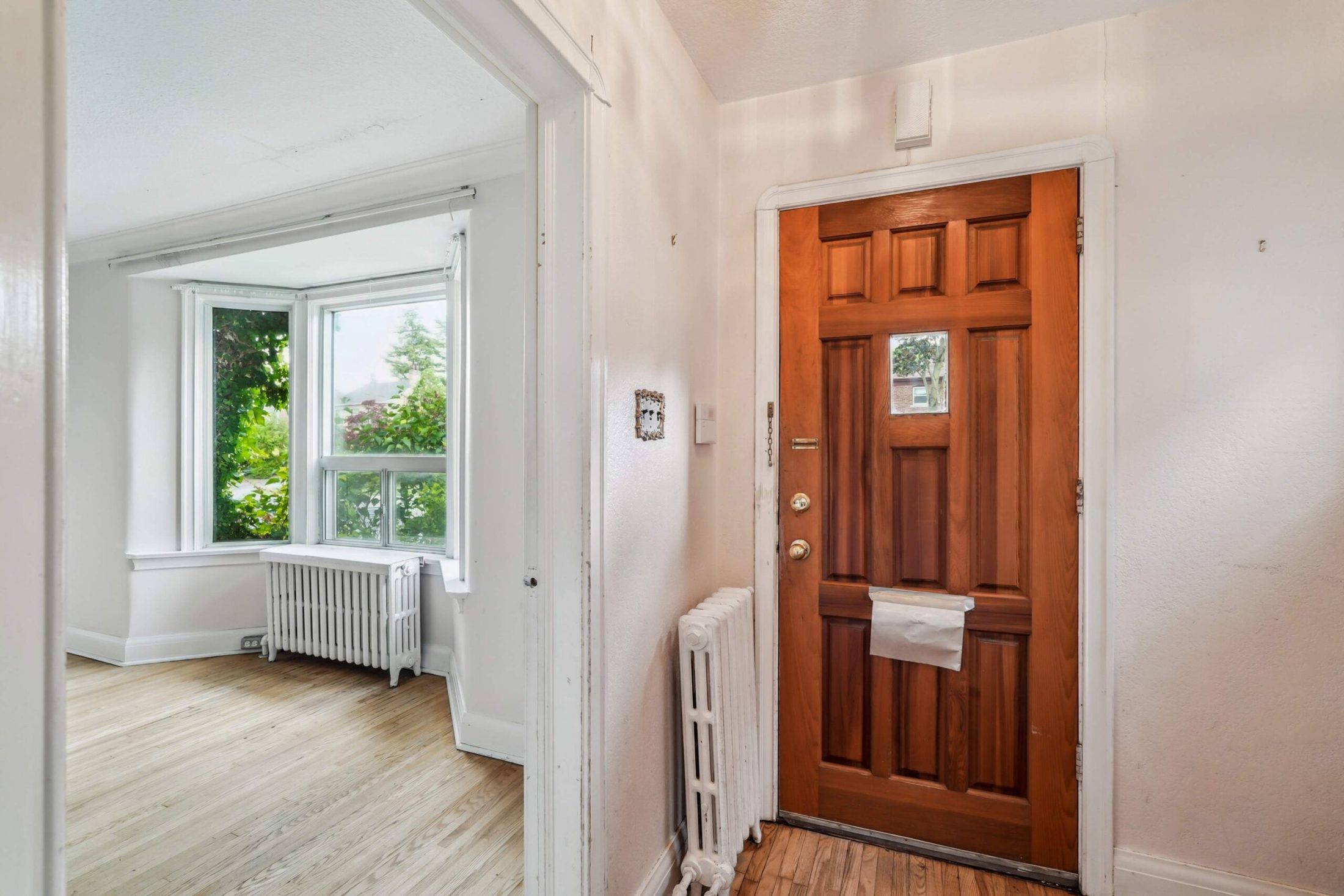 Entry foyer with original wood door and bay-window sitting area beyond