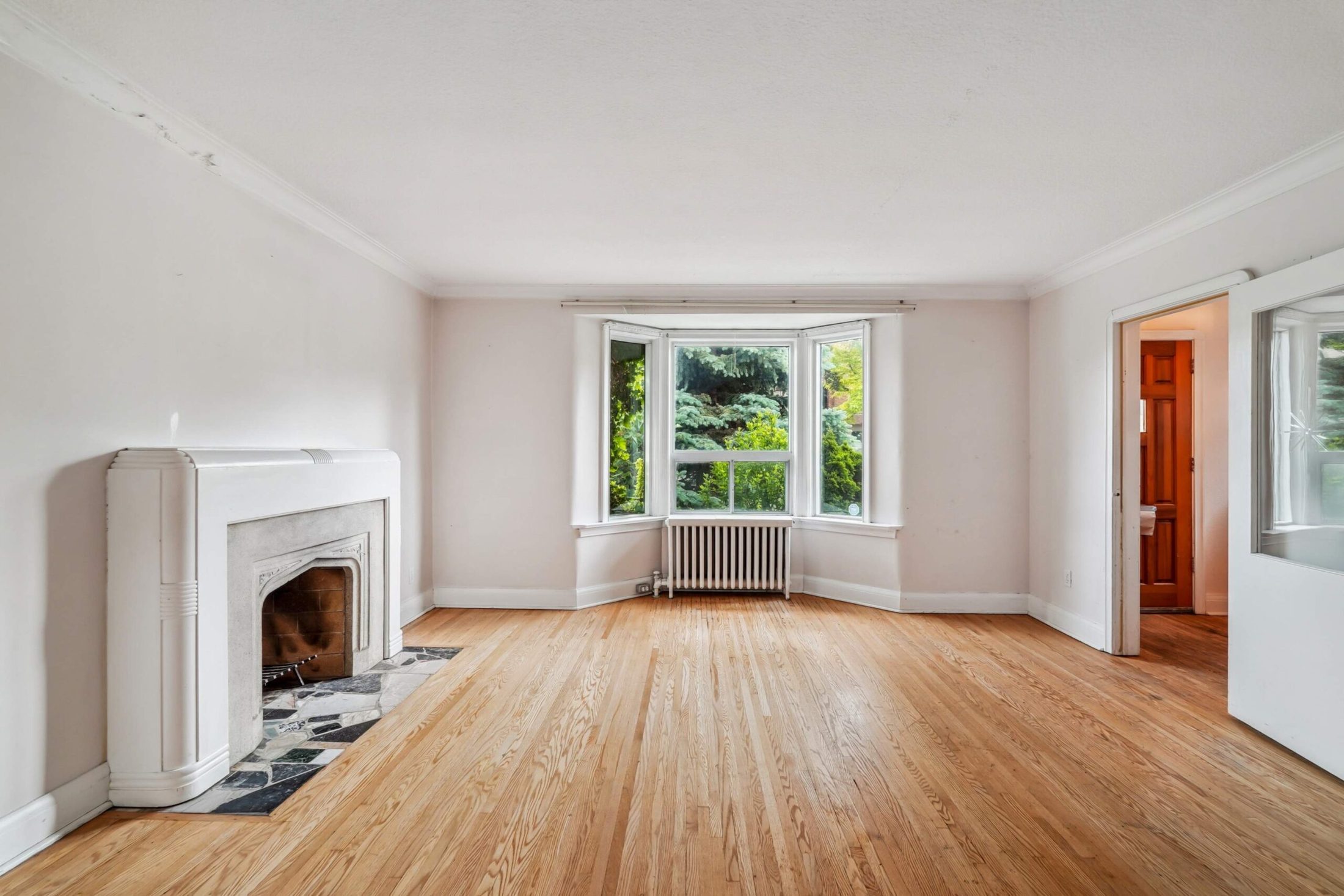 Living room with sculpted Art Deco fireplace and bay window