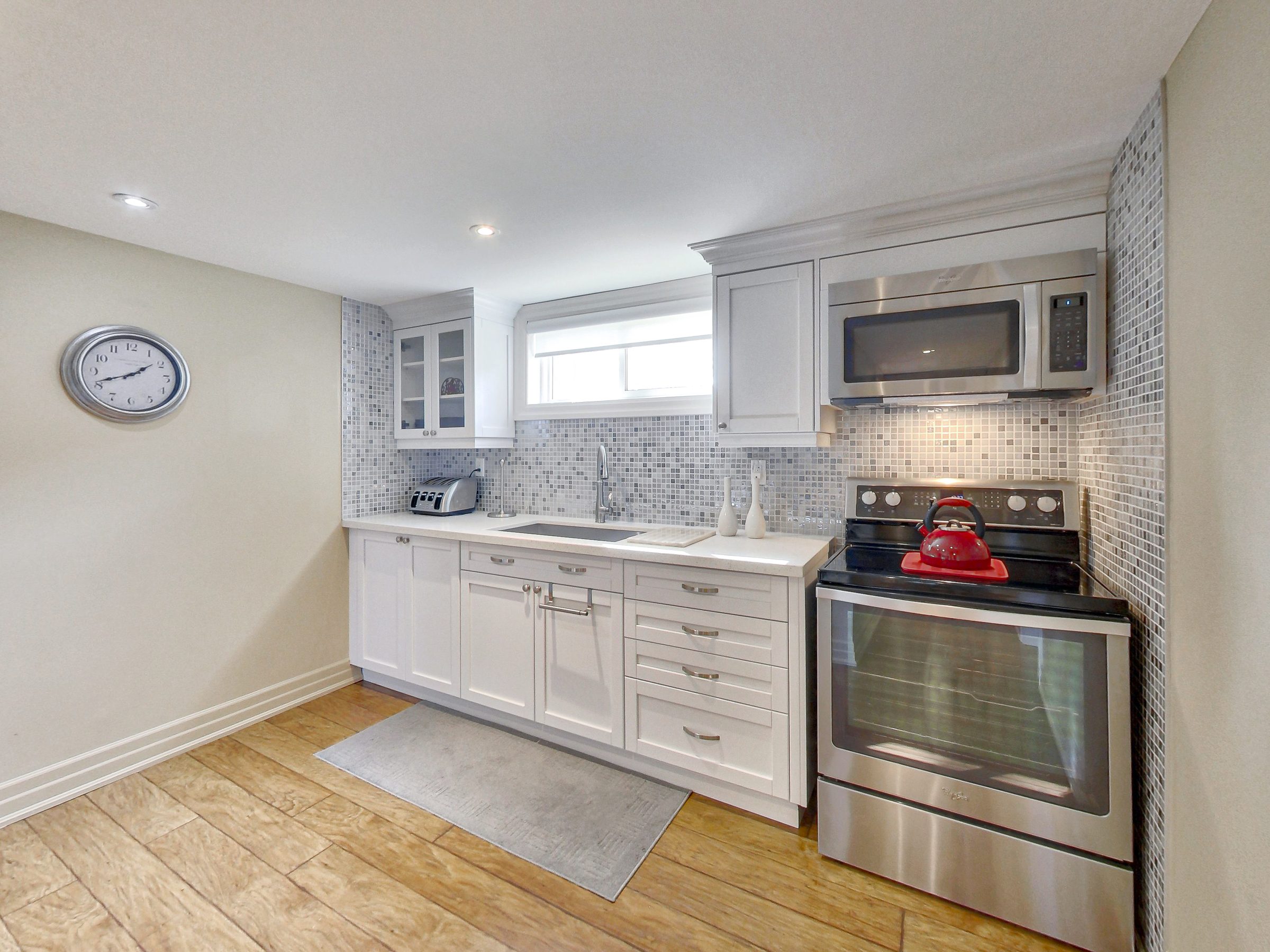 Kitchen with stainless range and microwave at 51 Norseman Street, Toronto