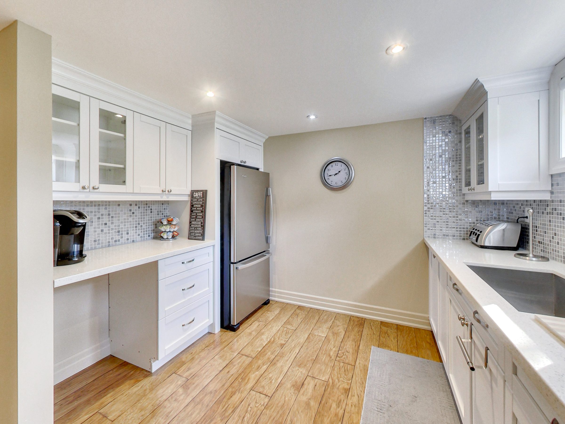 Kitchen with built-in desk and stainless fridge at 51 Norseman Street, Toronto