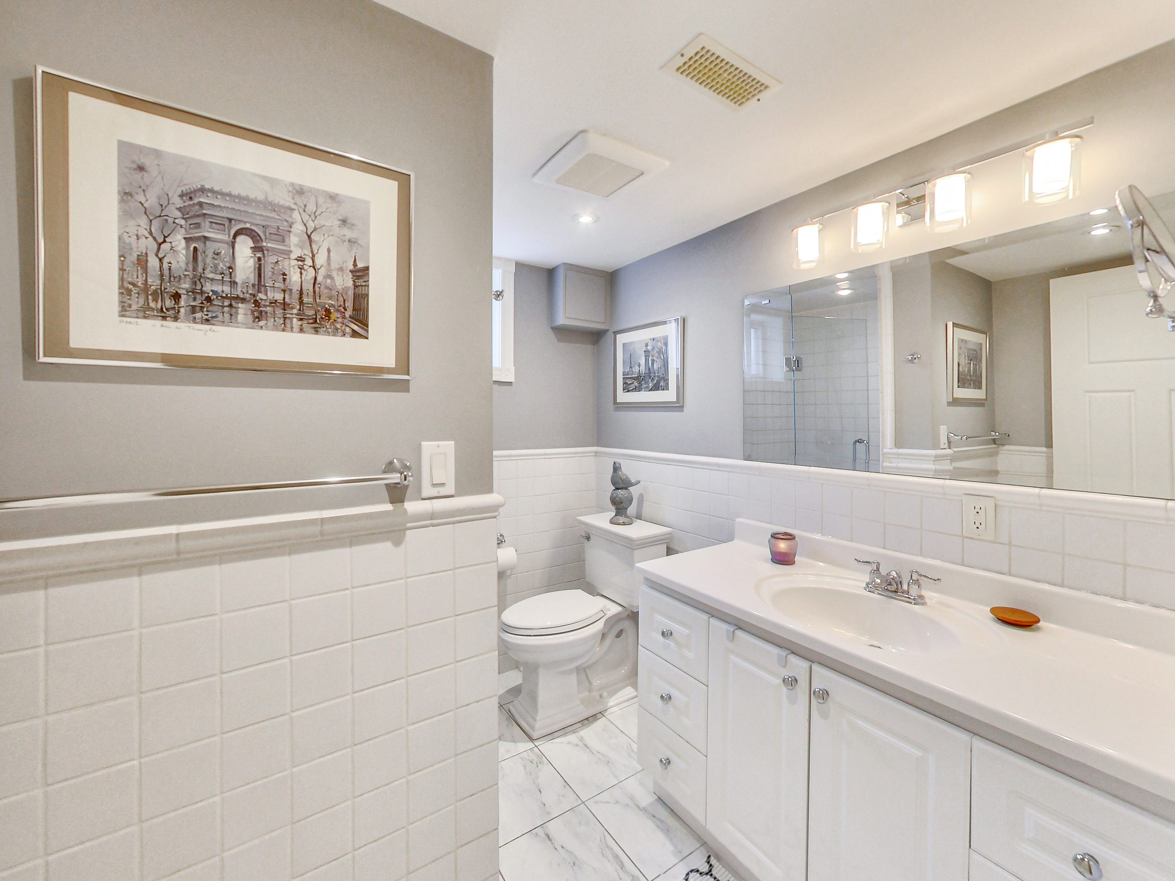 Bathroom with white vanity in the lower suite at 51 Norseman Street, Toronto