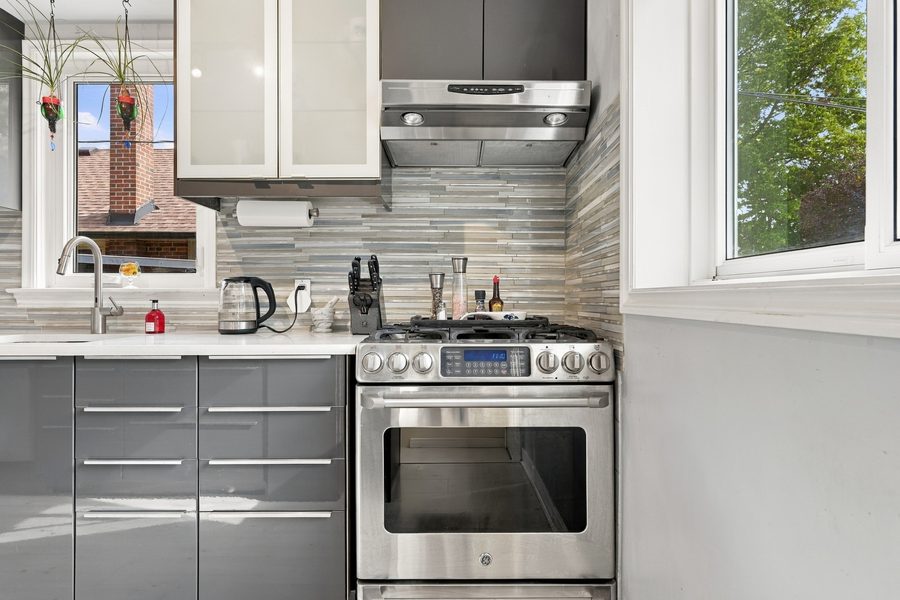 Kitchen with stainless steel gas range and range hood