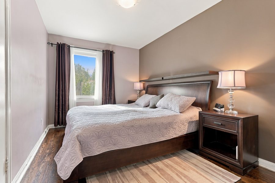 Primary bedroom with hardwood floors and a window to the garden